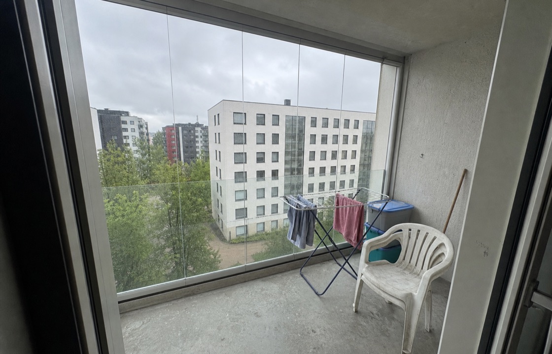 Glazed apartment balcony before: bare concrete floor, drying rack, plastic storage boxes and a single plastic chair