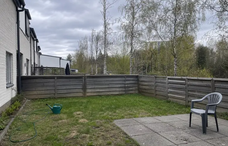 Helsinkiläinen rivitalon takapiha ennen: kulunut nurmi, betonilaatta ja sekalaisia tavaroita