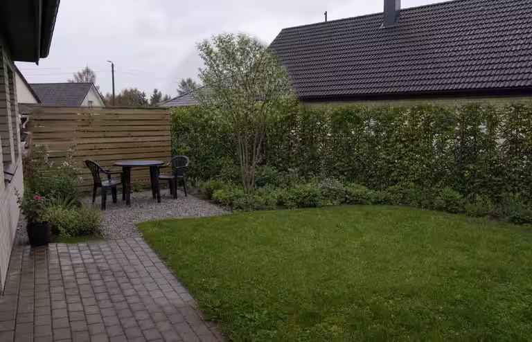 Ridaelamu väikese aia privaatsuslahendus istutuse ja puhkenurgaga